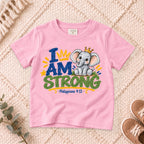 I AM Kids strong design on a Light Pink shirt, shown on a cream rug.