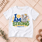 I AM Kids strong design on a White shirt, shown on a cream rug.