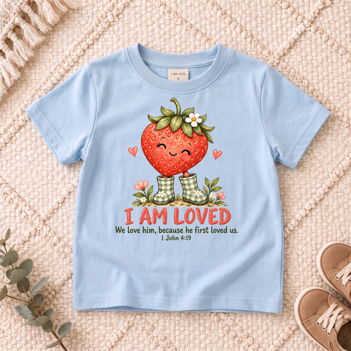 I AM Kids Strawberry design on a Light Blue shirt, shown on a cream rug.