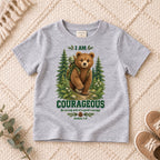 I AM COURAGEOUS woodland bear design on a Sport Grey kids shirt, photographed on a cream rug.