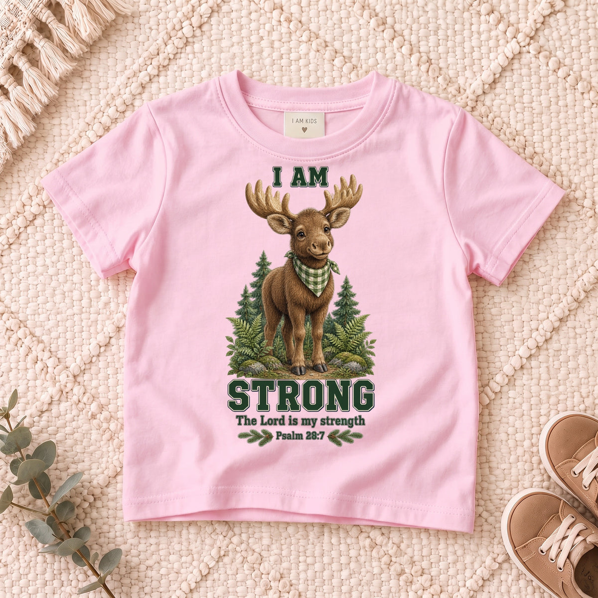 I AM Kids moose design on a Light Pink shirt, shown on a cream rug.