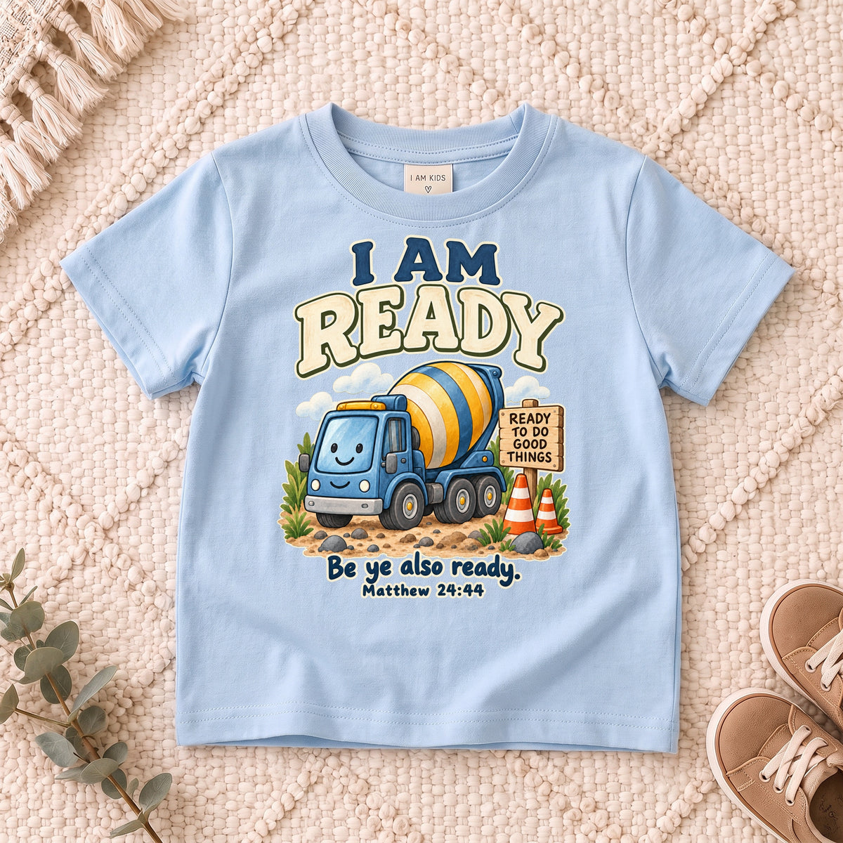 I AM Kids ready truck design on a Light Blue shirt, shown on a cream rug.