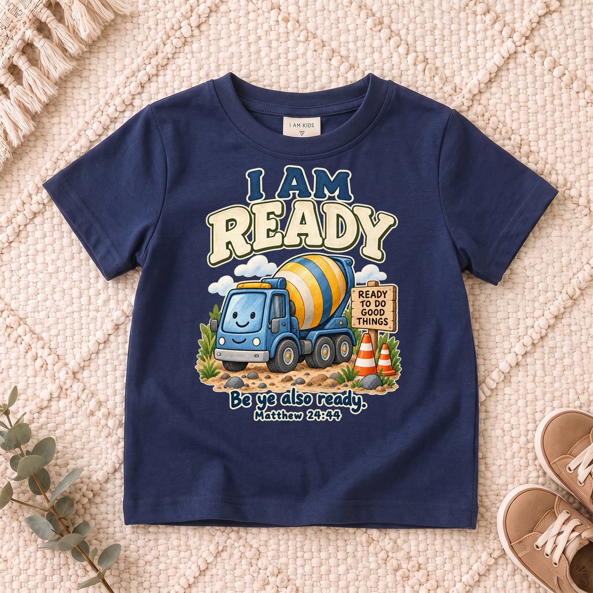 I AM Kids ready truck design on a Navy shirt, shown on a cream rug.