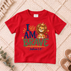 I AM Kids 2I AM BRAVE Lion Toddler T-Shirt | Joshua 1:9 - copy design on a Red shirt, shown on a cream rug.