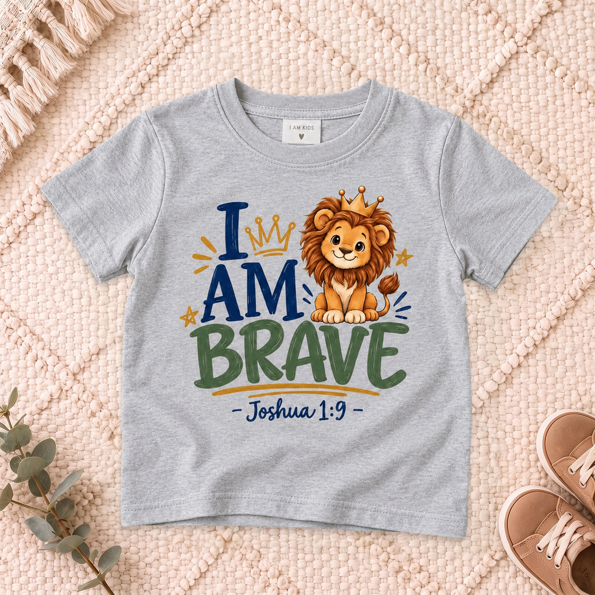 I AM Kids 2I AM BRAVE Lion Toddler T-Shirt | Joshua 1:9 - copy design on a Sport Grey shirt, shown on a cream rug.