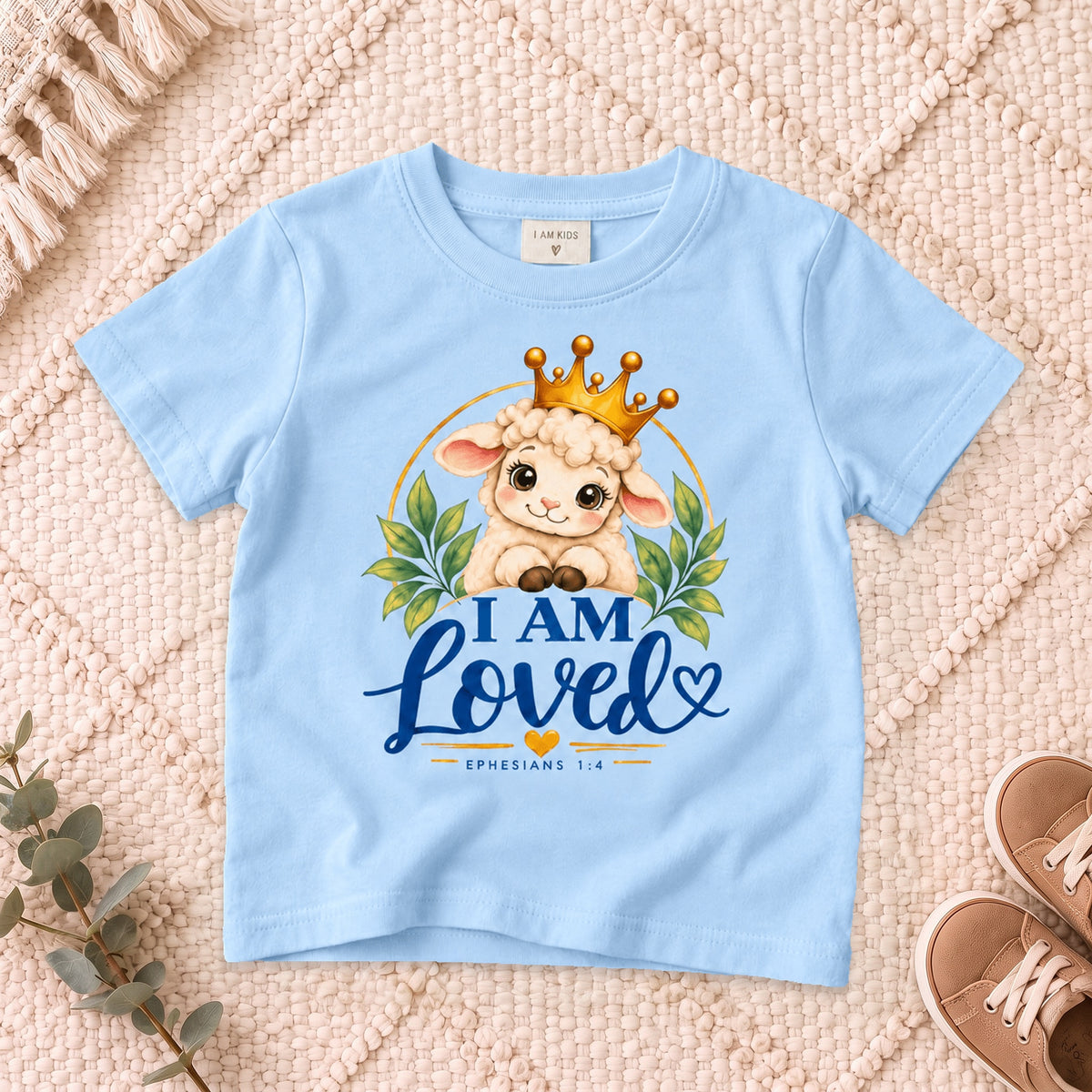 I AM Kids I AM LOVED Lamb Toddler T-Shirt | Ephesians 1:4 - copy design on a Light Blue shirt, shown on a cream rug.