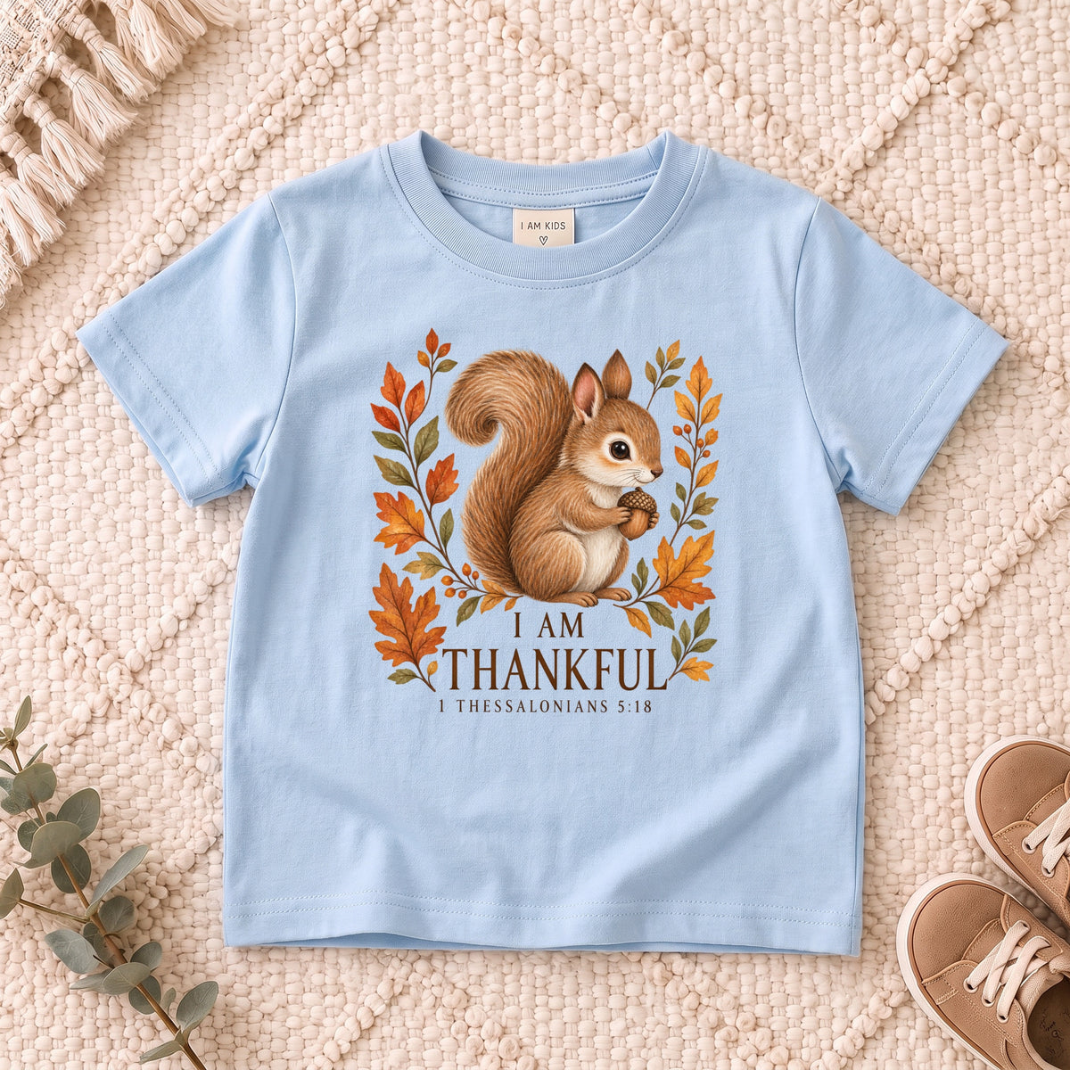 I AM Kids squirrel design on a Light Blue shirt, shown on a cream rug.