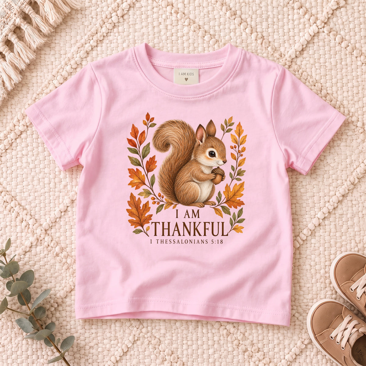 I AM Kids squirrel design on a Light Pink shirt, shown on a cream rug.