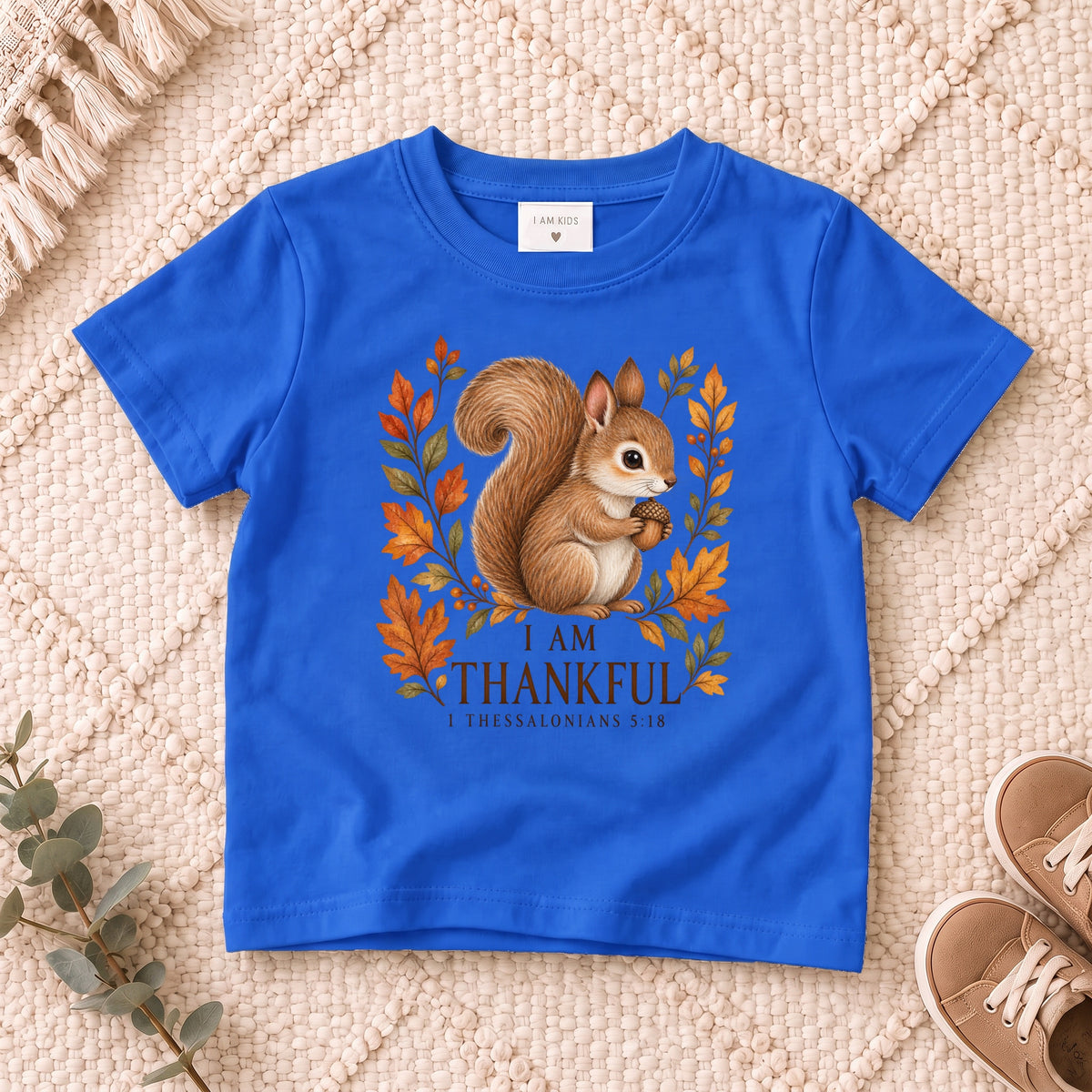 I AM Kids squirrel design on a Royal shirt, shown on a cream rug.