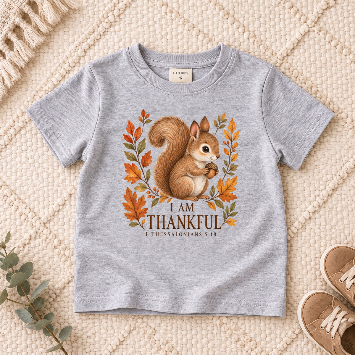 I AM Kids squirrel design on a Sport Grey shirt, shown on a cream rug.