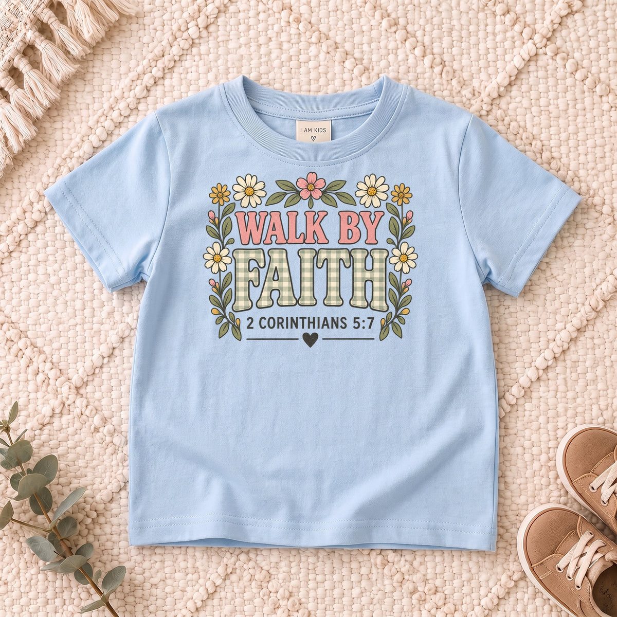 I AM Kids walk by faith bow design on a Light Blue shirt, shown on a cream rug.