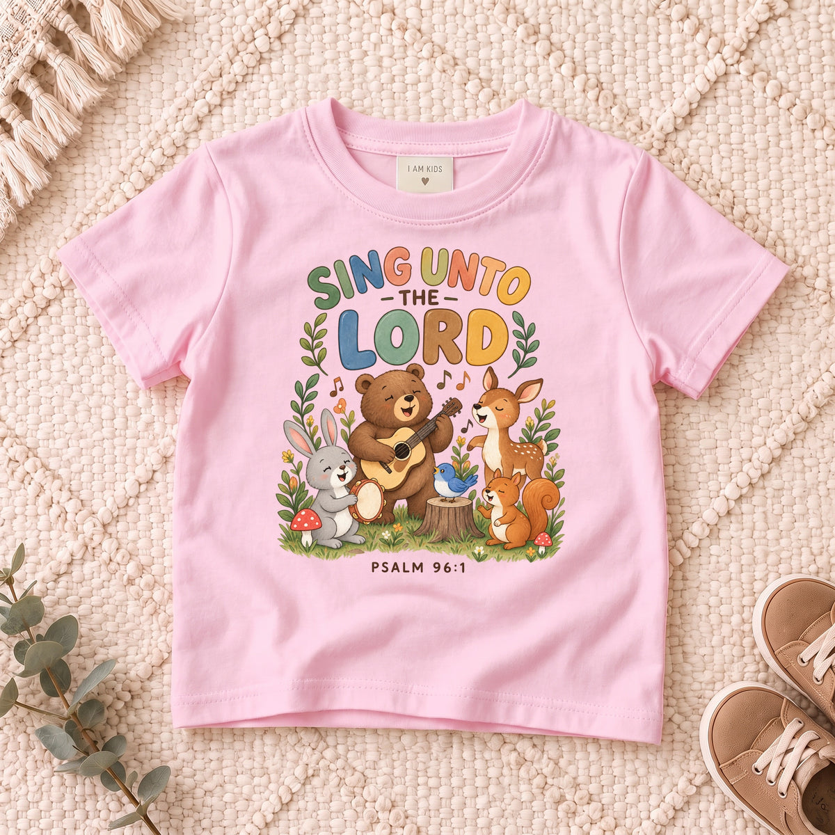 I AM Kids sing bear design on a Light Pink shirt, shown on a cream rug.