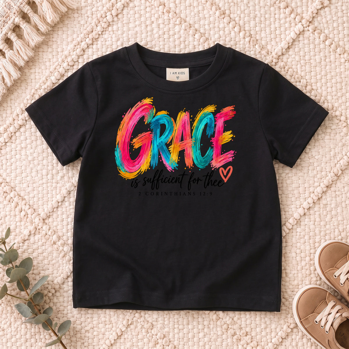 I AM Kids grace design on a Black shirt, shown on a cream rug.