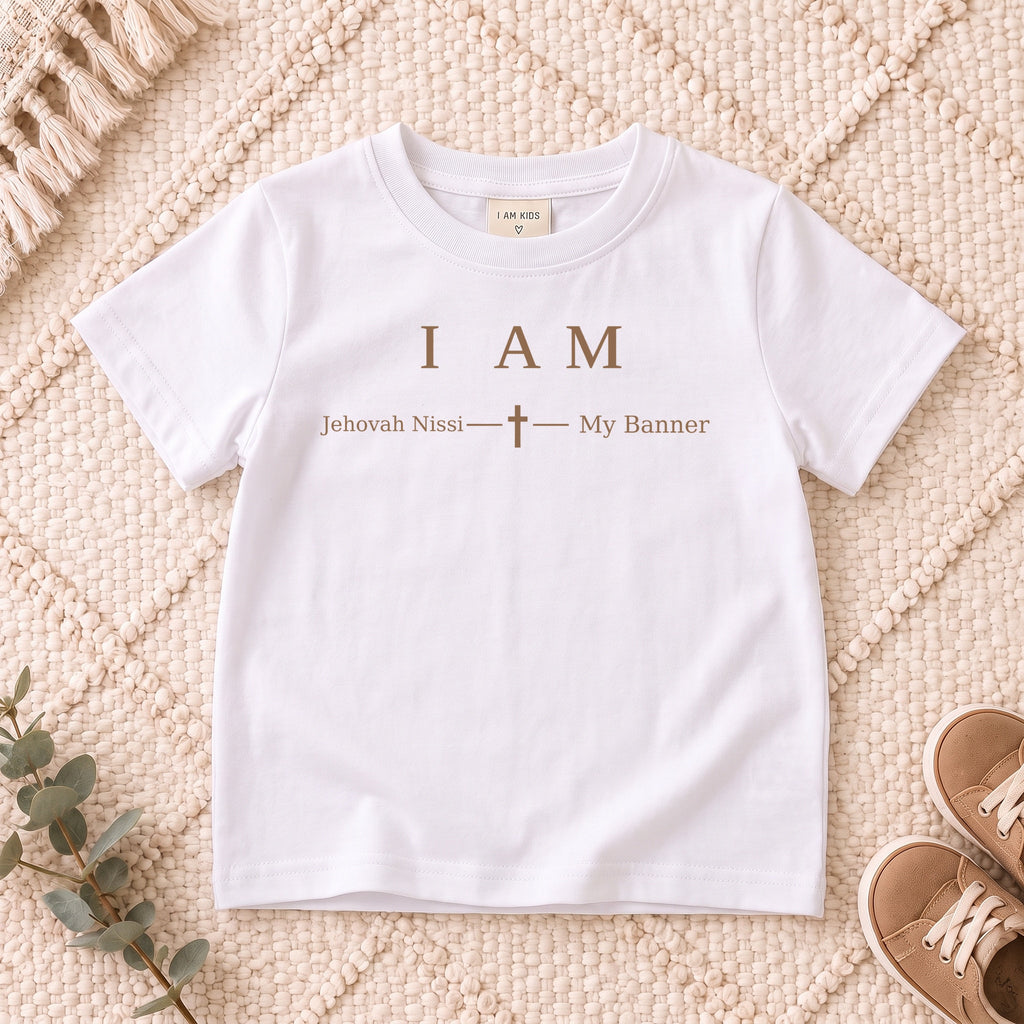 I AM Kids Jehovah Nissi — My Banner | The Great I AM Collection design on a White shirt, shown on a cream rug.