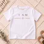 I AM Kids Jehovah Jireh — Provider | The Great I AM Collection design on a White shirt, shown on a cream rug.