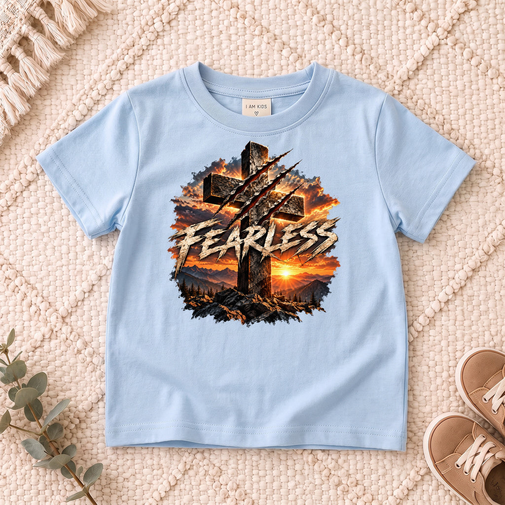 I AM Kids FEARLESS Cross Kids Tee design on a Light Blue shirt, shown on a cream rug.
