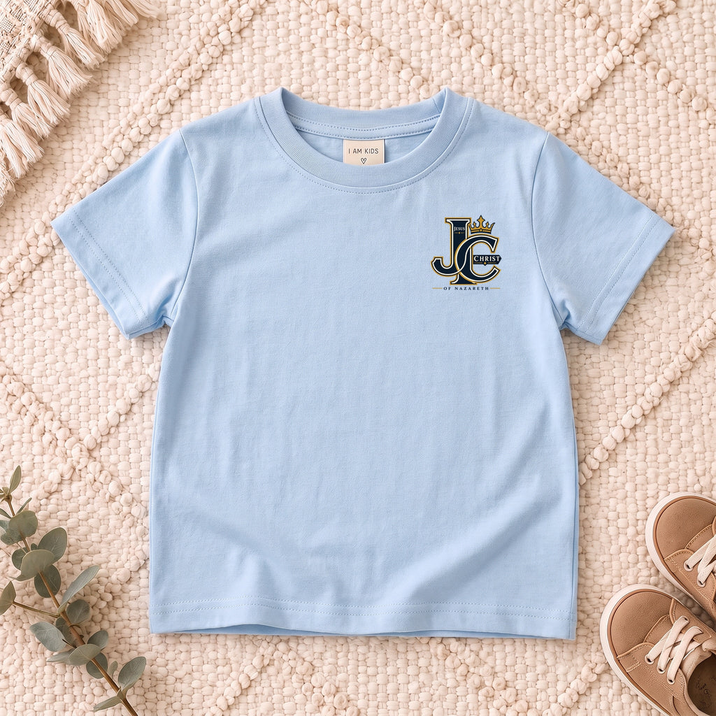 I AM Kids Crowned JC Jesus Christ Kids Tee | Left Chest design on a Light Blue shirt, shown on a cream rug.