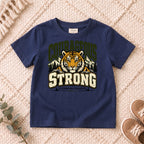 I AM Kids Be Strong & Courageous Tiger Kids Tee design on a Navy shirt, shown on a cream rug.