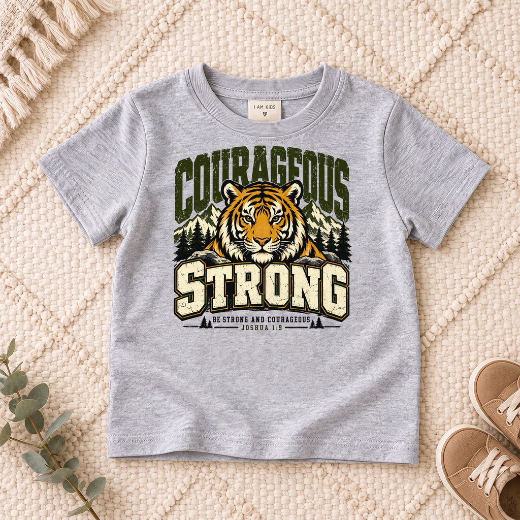 I AM Kids Be Strong & Courageous Tiger Kids Tee design on a Sport Grey shirt, shown on a cream rug.