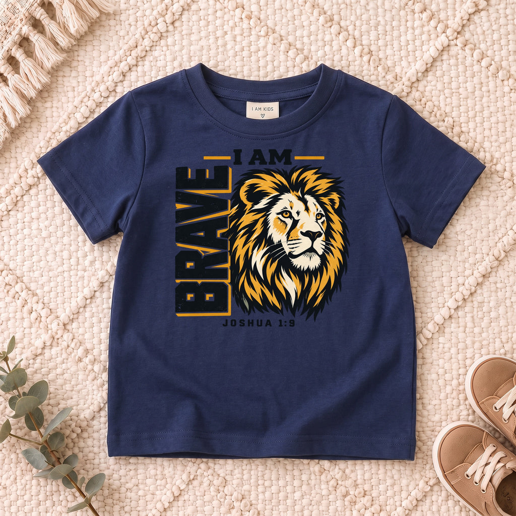 I AM Kids I AM Brave Lion Kids Tee | Joshua 1:9 design on a Navy shirt, shown on a cream rug.