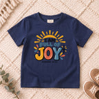 I AM Kids I AM Full of Joy Sunshine Kids Tee | Romans 15:13 design on a Navy shirt, shown on a cream rug.