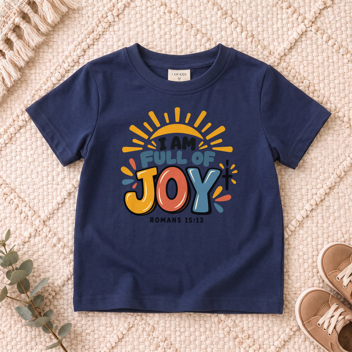 I AM Kids I AM Full of Joy Sunshine Kids Tee | Romans 15:13 design on a Navy shirt, shown on a cream rug.