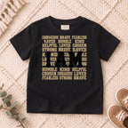 I AM Kids I AM Words of Faith Kids Tee design on a Black shirt, shown on a cream rug.