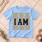 I AM Kids I AM Words of Faith Kids Tee design on a Light Blue shirt, shown on a cream rug.