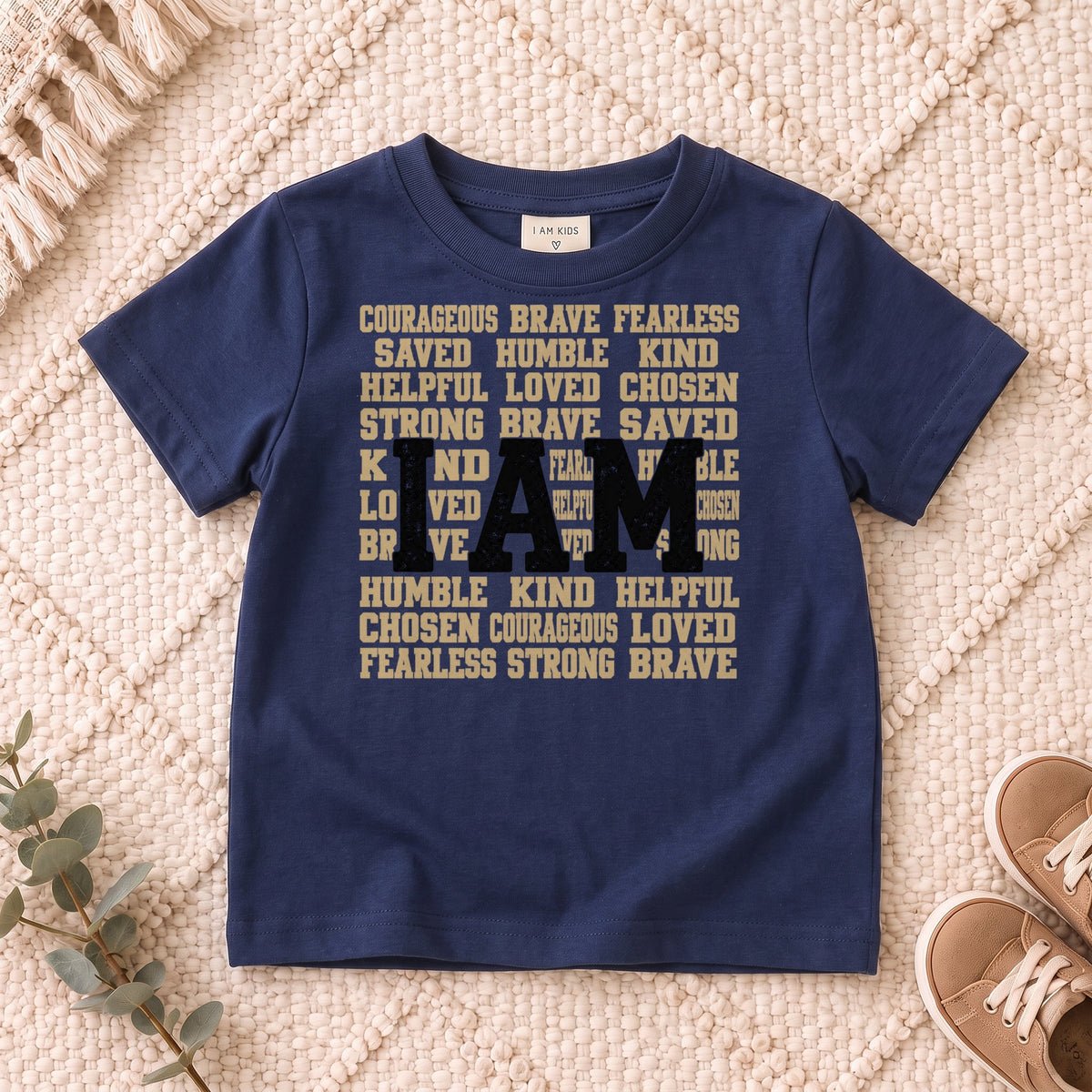 I AM Kids I AM Words of Faith Kids Tee design on a Navy shirt, shown on a cream rug.