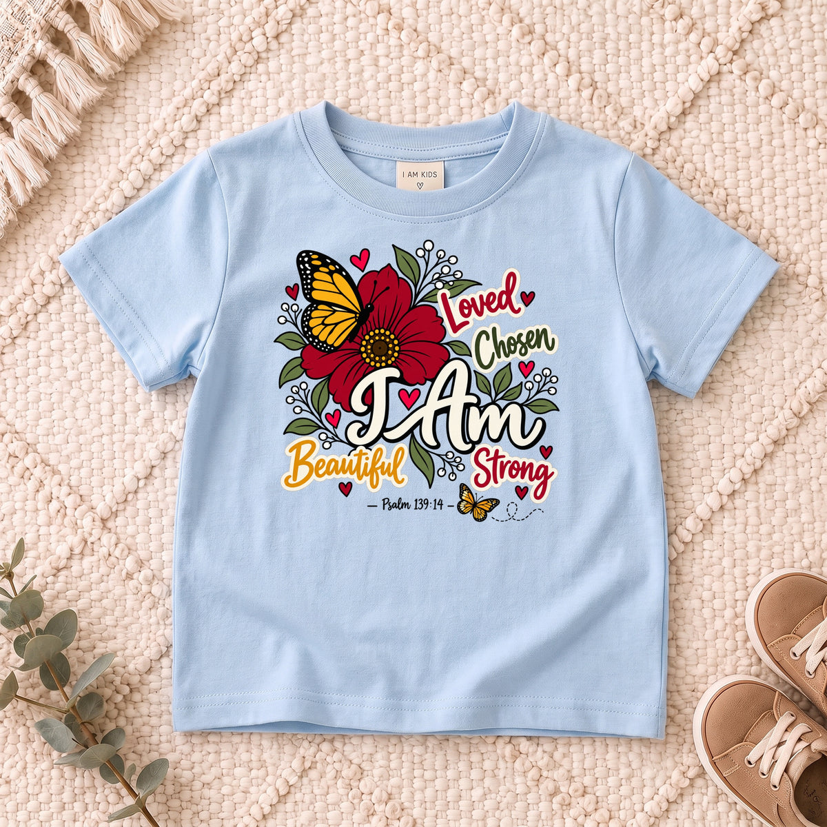 I AM Kids I AM Beautiful & Strong Floral Butterfly Kids Tee | Psalm 139:14 design on a Light Blue shirt, shown on a cream rug.