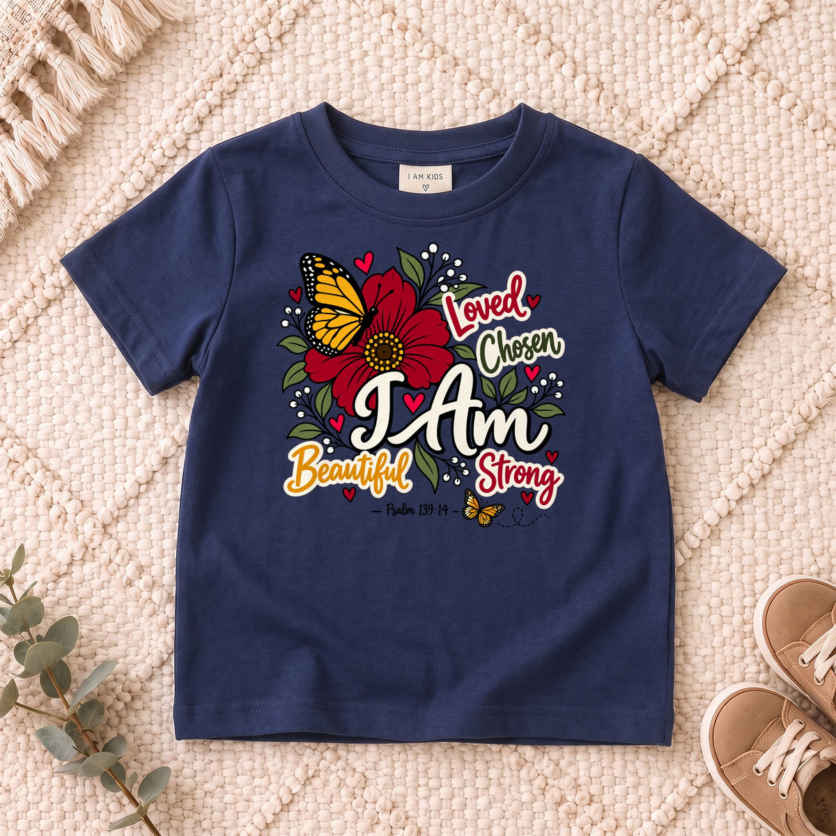 I AM Kids I AM Beautiful & Strong Floral Butterfly Kids Tee | Psalm 139:14 design on a Navy shirt, shown on a cream rug.