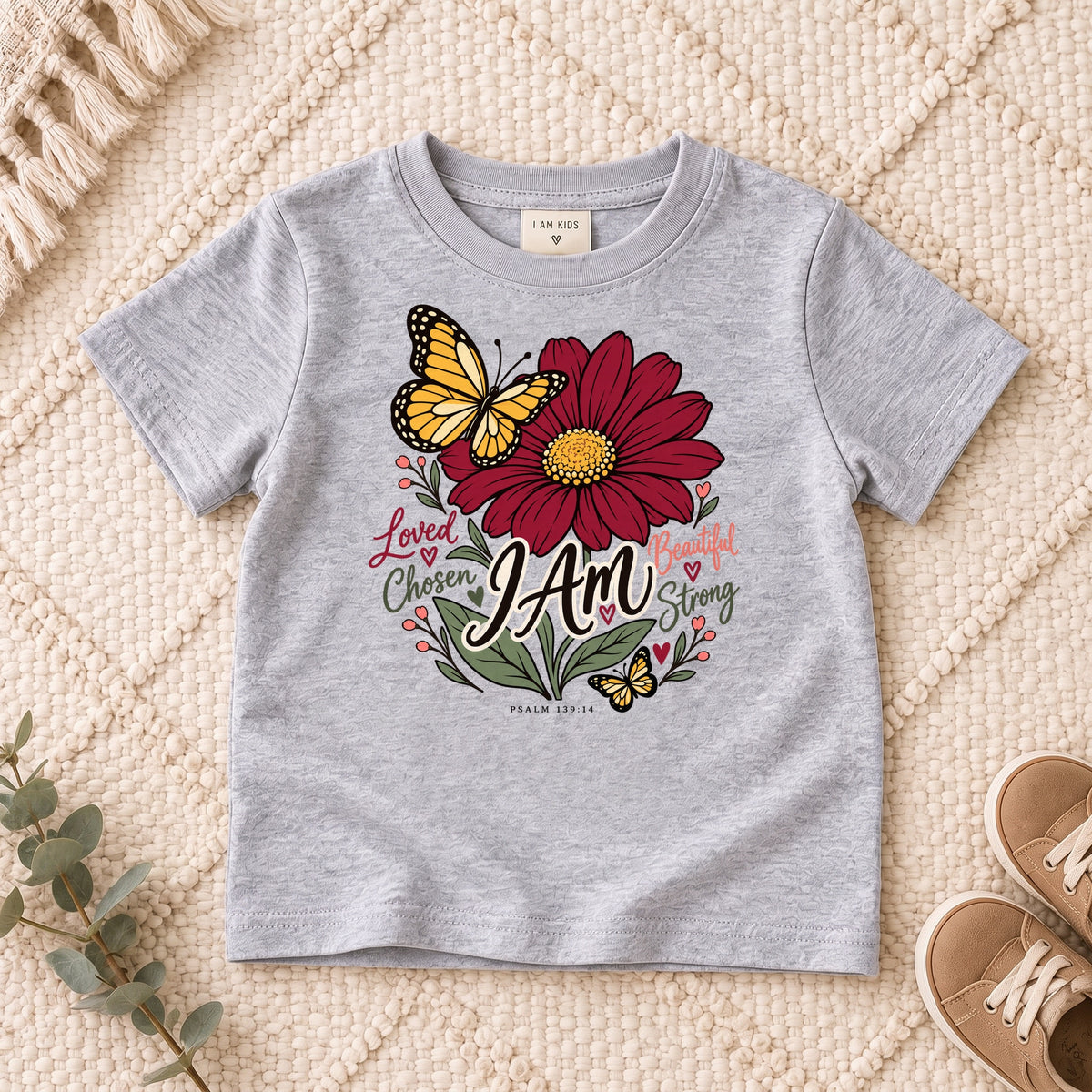 I AM Kids I AM Loved & Chosen Burgundy Flower Kids Tee | Psalm 139:14 design on a Sport Grey shirt, shown on a cream rug.